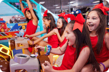 Children wearing red with red bows playing an arcade game