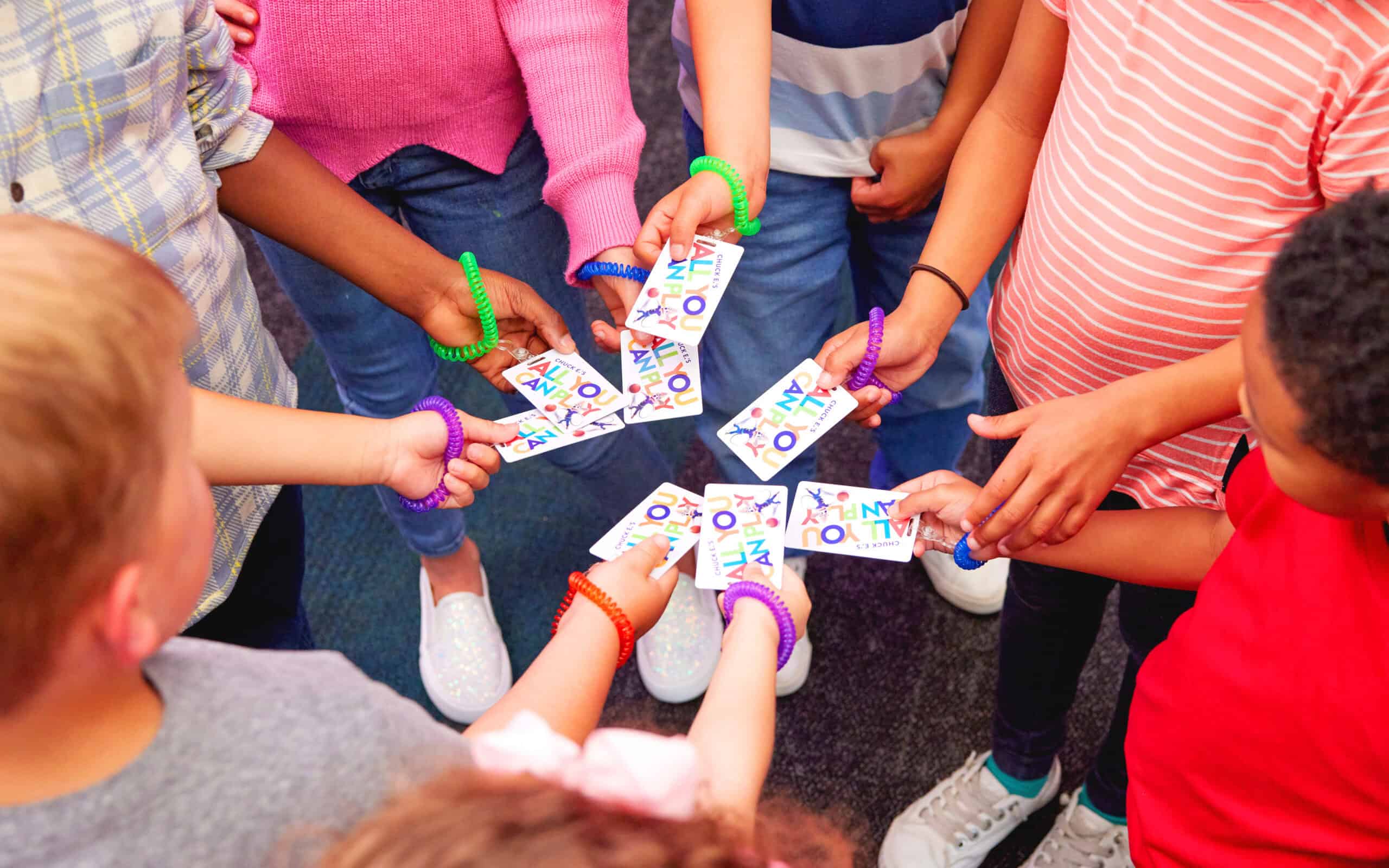 kids holding Chuck E. Cheese Play Passes