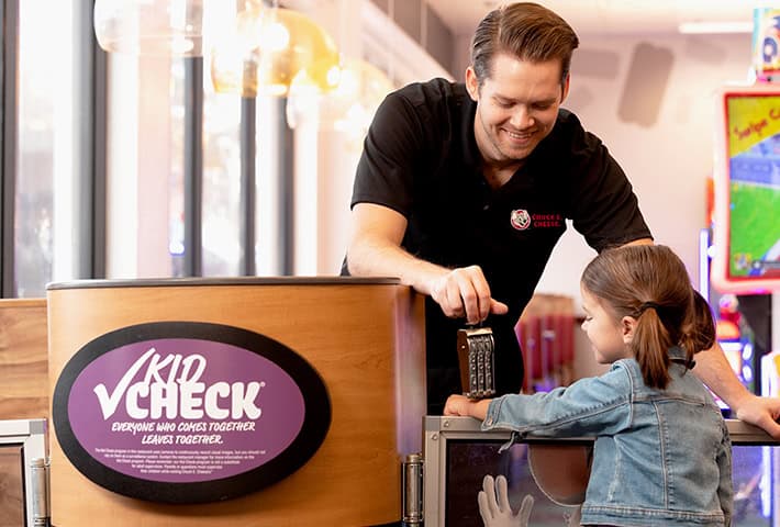 chuck e cheese cast member stamping hand of entering child to chuck e cheese