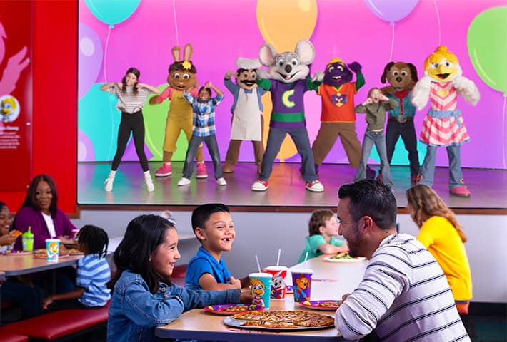 chuck e. cheese and munch's make believe band putting a show on stage with kids for families at chuck e. cheese