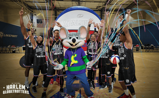 The Harlem Globetrotters join kids and Chuck E. Cheese mascot at a birthday party with streamers, arcade games, pizza, and Fun Pass.