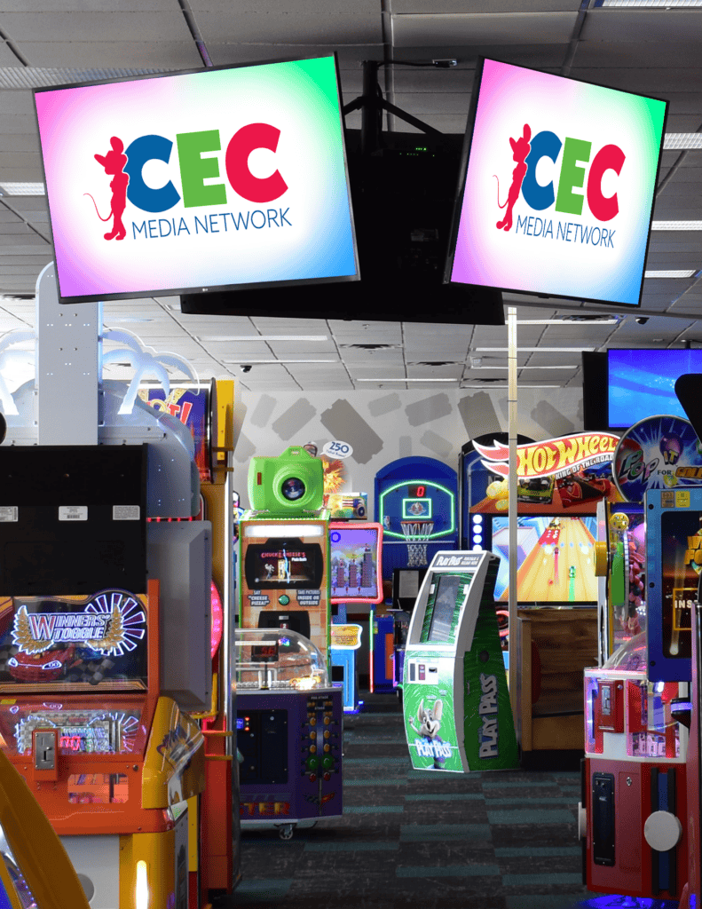 Chuck E. Cheese family fun center arcade with basketball and racing games, CEC Media Network screens, pizza tables, and Fun Pass kiosks.