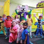 Children in superhero costumes with Chuck E. Cheese