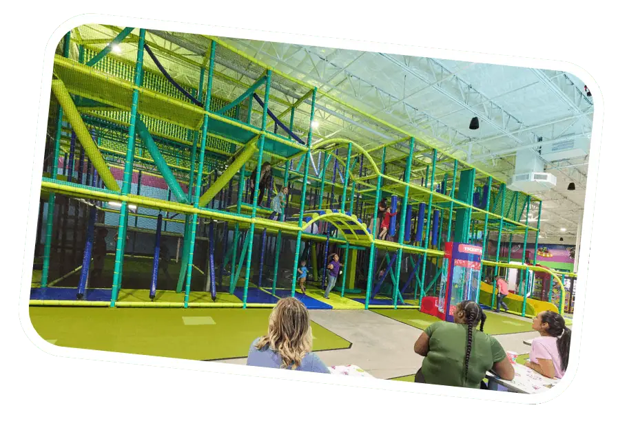 Kids climbing and playing on the colorful Superhero Playground at Chuck E. Cheese