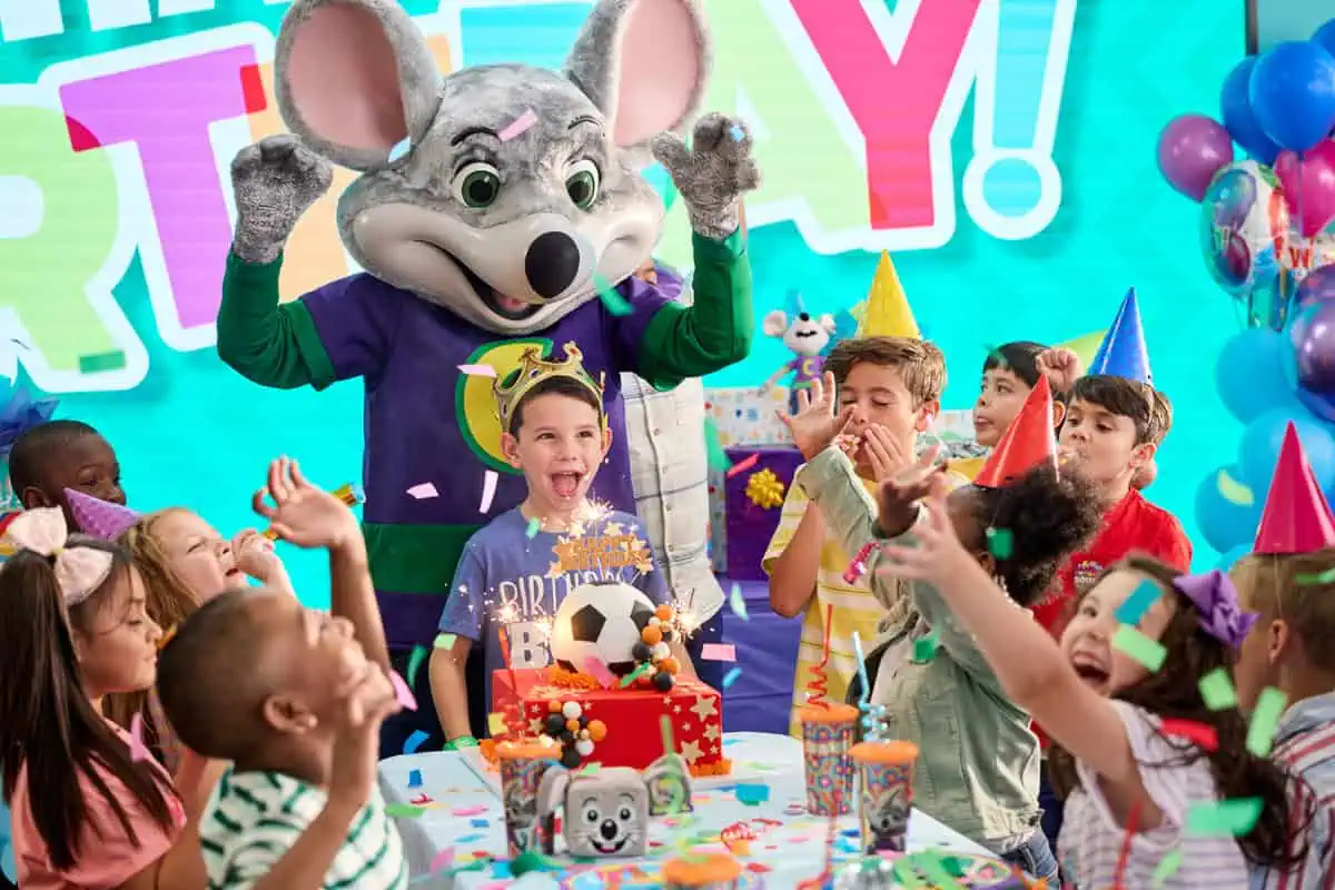 A group of partygoers and Chuck E. Cheese
