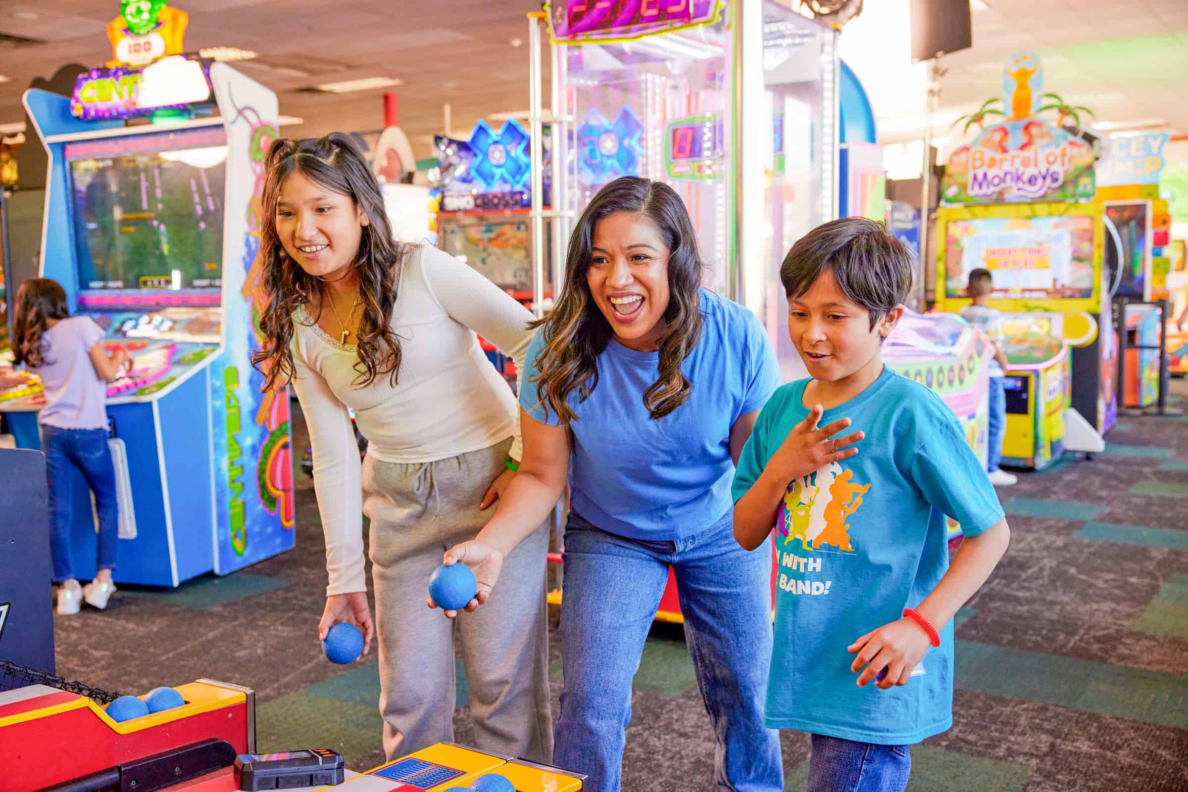 Kids play skee-ball together at Chuck E. Cheese during a party — fully indoors, weather-proof entertainment