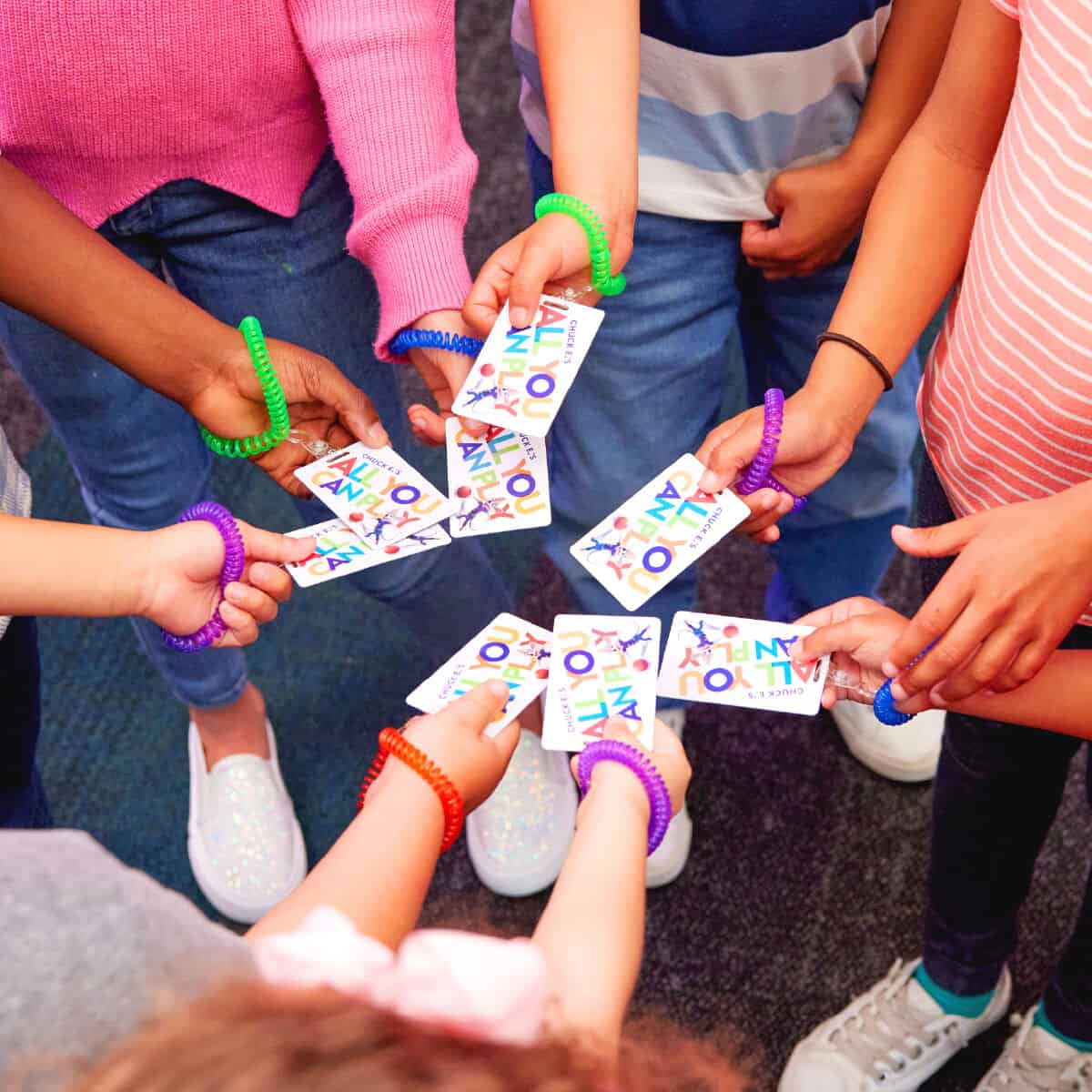 Kids holding Fun Pass wristbands at Chuck E. Cheese