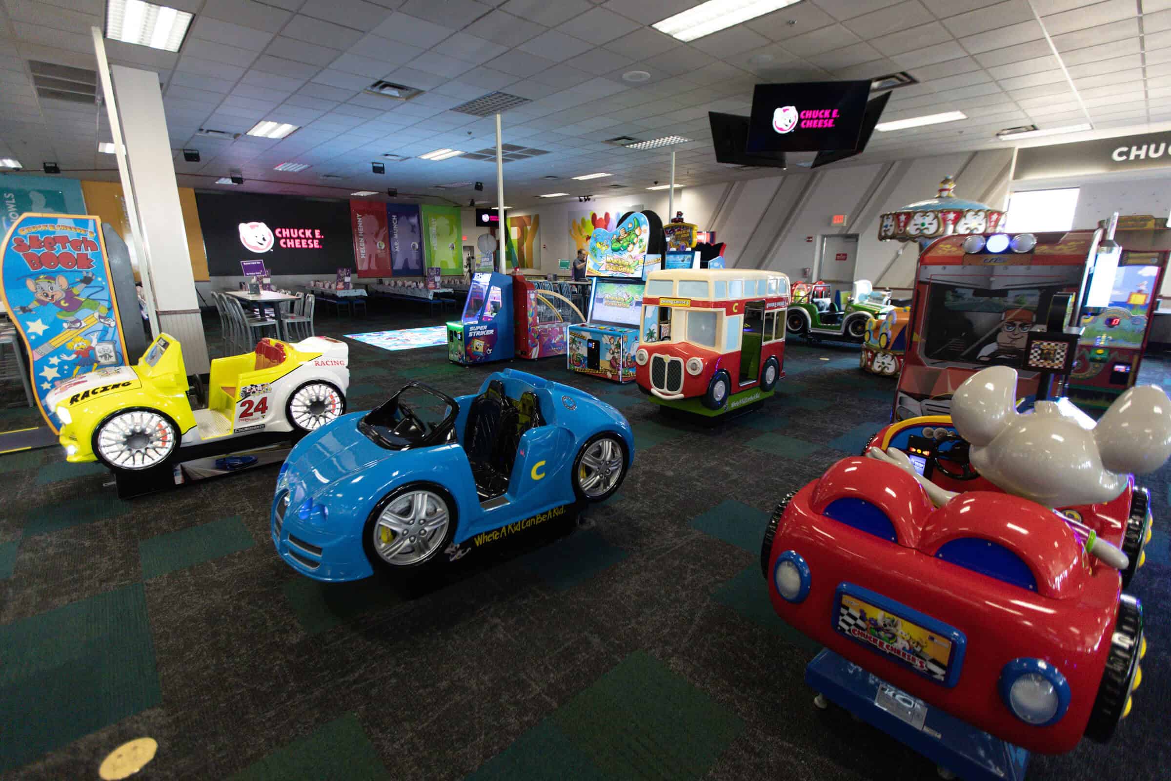 Chuck E. Cheese arcade floor with various car-themed kiddie rides during Sensory Sensitive Sundays