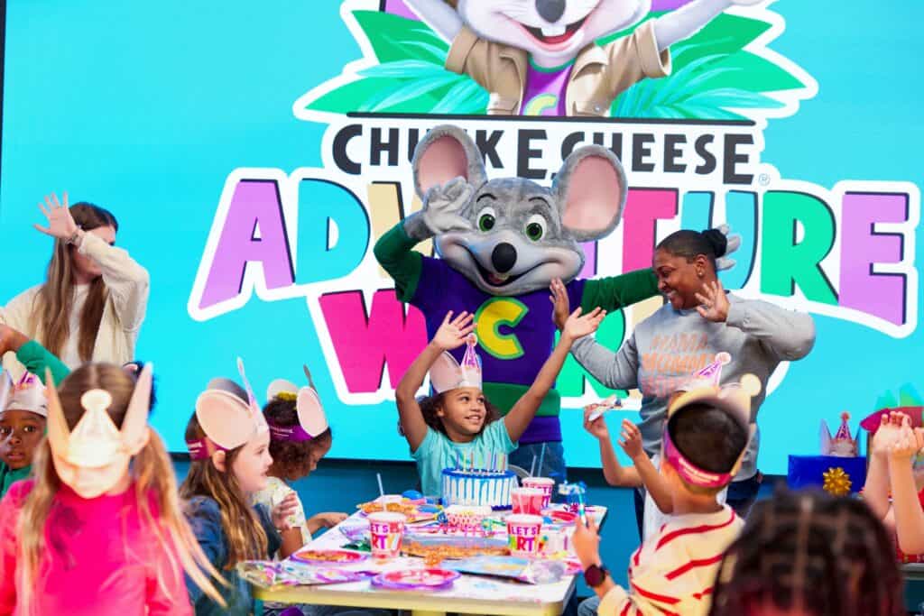 Young child in safety goggles catching tickets in the Ticket Blaster at Chuck&nbsp;E.&nbsp;Cheese.