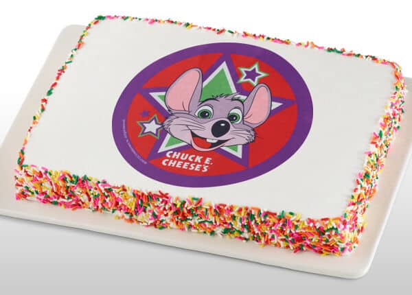 Chuck E. Cheese cake with cartoon character topper and rainbow sprinkles.