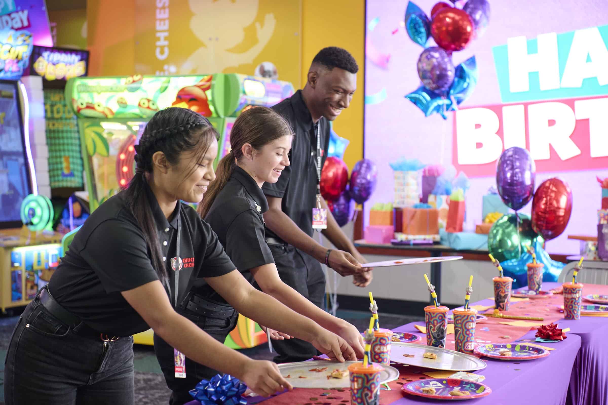 Birthday party table set up with pizza, drinks, and colorful decorations at Chuck&nbsp;E.&nbsp;Cheese.