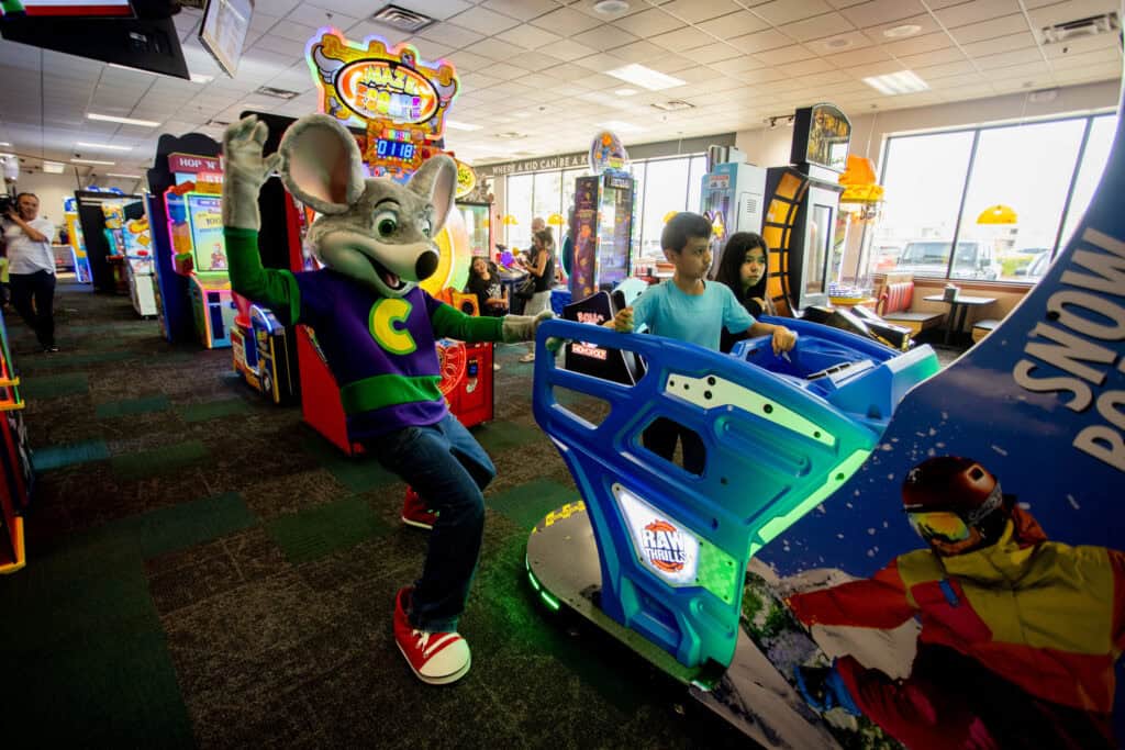 Kids playing an arcade game together at Chuck&nbsp;E.&nbsp;Cheese.