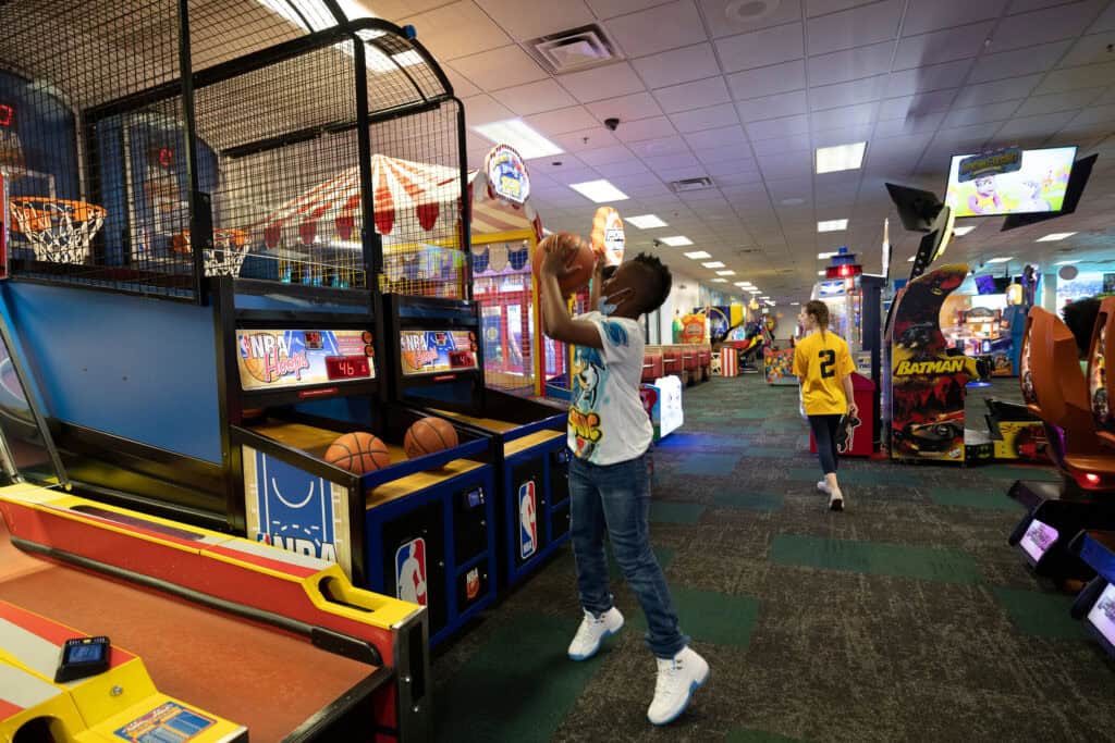 Toddler tapping and swiping a large colorful touchscreen arcade game